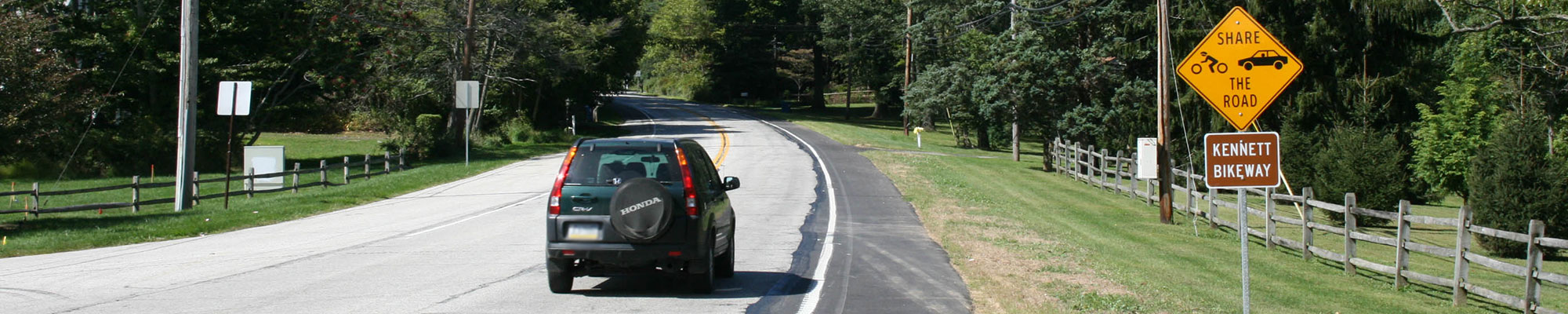 share the road sign on road